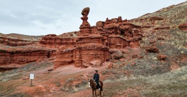 A visitor rides a horse through the red valleys of the Narman Fairy Chimneys, Erzurum, Türkiye, Feb. 17, 2026. (AA Photo) 