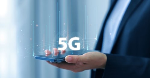 A person holds a smartphone with a 5G icon. (Shutterstock Photo)