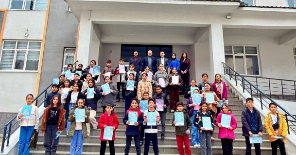 Students pose with their booklets after taking the reading contest exam at their school in eastern Hakkari province, Türkiye, March 29, 2026. (Photo Courtesy of TÜGVA)