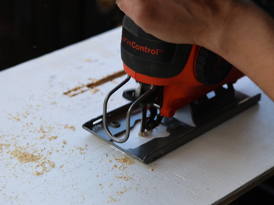 Felicia Fonseca uses a jigsaw to cut slits into a piece of plywood for a wedding sign at a do-it-yourself party at an apartment in Flagstaff, Ariz., U.S., Feb. 15, 2026. (AP Photo)