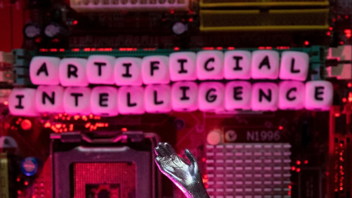 AI (Artificial Intelligence) letters and robot hand are placed on computer motherboard in this illustration taken, June 23, 2023. (Reuters Photo)