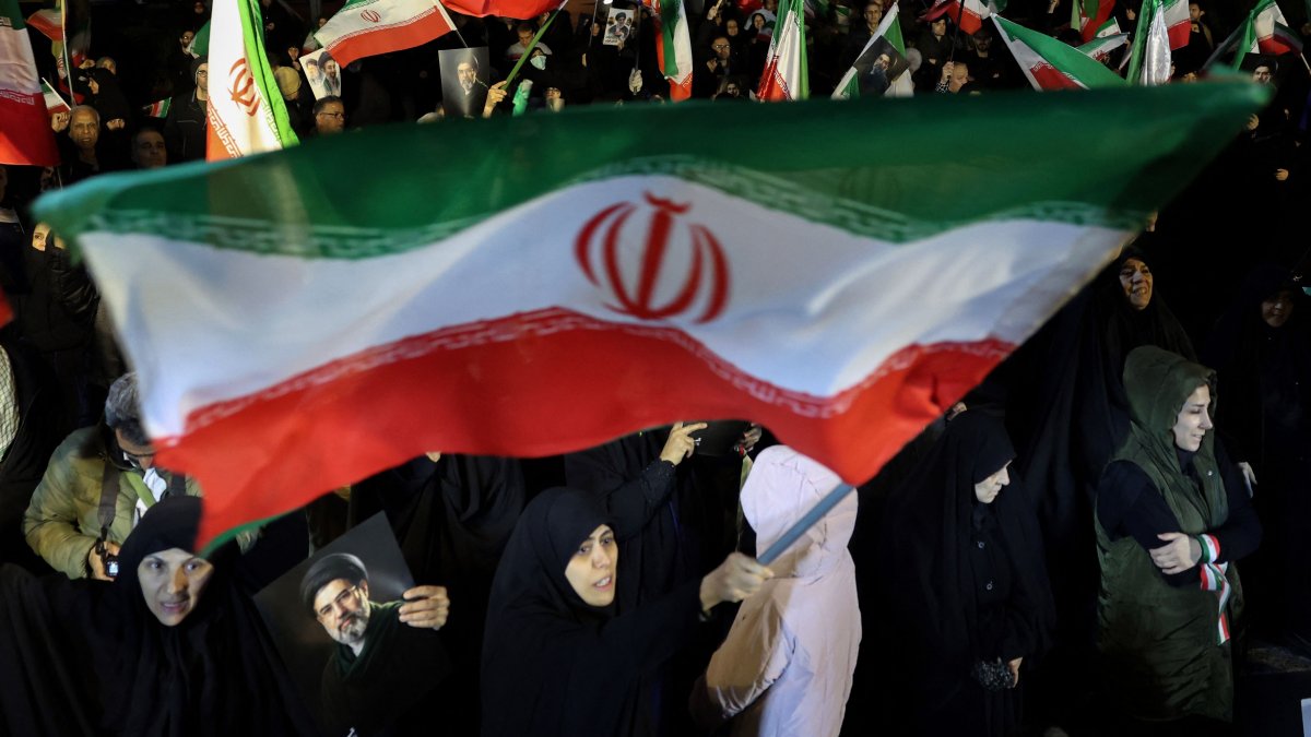 People wave national flags and hold portraits of Iran's Supreme Leader Mojtaba Khamenei as they march in Tehran, Iran, March 25, 2026.  (AFP Photo)