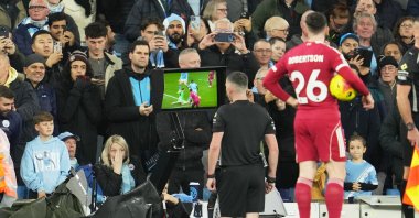 Referee Chris Kavanagh pauses the match and checks the VAR screen during the English Premier League match between Manchester City and Liverpool, Manchester, London, Nov. 9, 2025. (AP Photo)