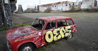 An old car next to an abandoned steel plant, Charleroi, southern Belgium, March 11, 2026. (AFP Photo)