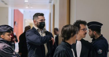 Defendant French military member Carl Esnault (C) and his lawyer Romain Ruiz (2nd R) arrive for the opening of the so-called Athanor trial, in which 22 people are facing a wide range of charges, including murder, centred on the Athanor Masonic lodge accused of running hit squads, at the Assize Court in the Tribunal Judiciaire courthouse in Paris, March 30, 2026. (AFP Photo)