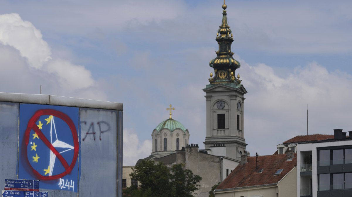 A graffiti against the EU and NATO is seen on a bridge in front of the Cathedral Church of St. Michael the Archangel, Belgrade, Serbia, July 30, 2025. (AP Photo)