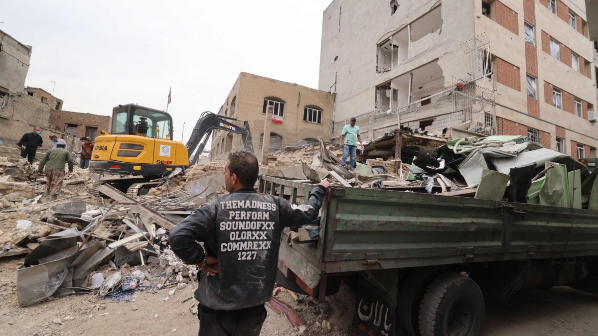 A digger removes the debris following damage to a residential building in the Iranian capital Tehran, March 15, 2026. (AFP File Photo)