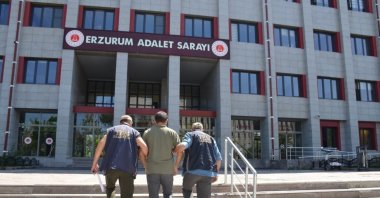Two police officers escort a detained FETÖ suspect, Erzurum, eastern Türkiye, July 18, 2025. (AA Photo)