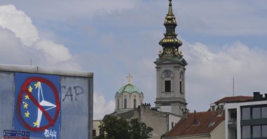 A graffiti against the EU and NATO is seen on a bridge in front of the Cathedral Church of St. Michael the Archangel, Belgrade, Serbia, July 30, 2025. (AP Photo)
