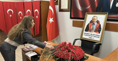 People leave flowers at the desk of Mehmet Selim Kiraz near a photo of the slain prosecutor, Istanbul, Türkiye, March 31, 2026. (IHA Photo)