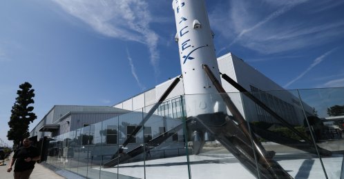 People walk past a SpaceX Falcon 9 rocket displayed outside the Space Exploration Technologies Corp. facility in Hawthorne, California, U.S., March 26, 2026. (AFP Photo)