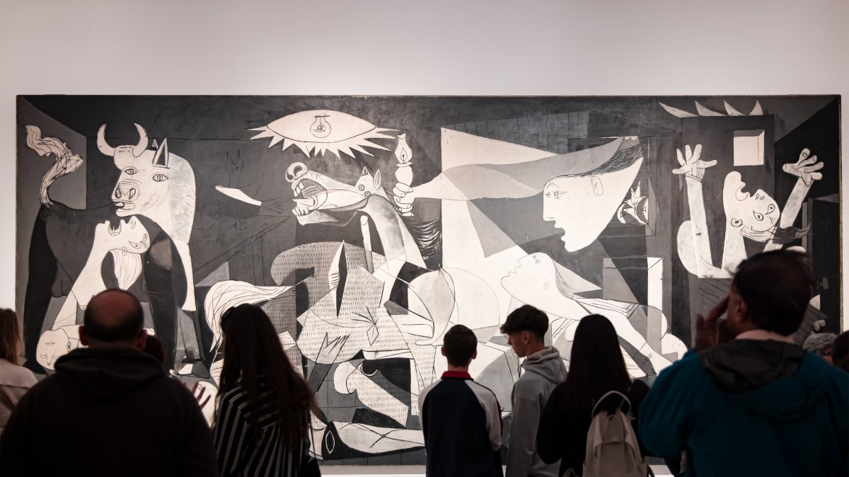 Visitors look at the "Guernica" oil painting by Spanish artist Pablo Picasso at Reina Sofia Museum, Madrid, Spain, March 25, 2024. (Shutterstock Photo)