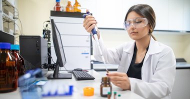 A female researcher wearing protective goggles uses a micropipette to handle liquid samples in a laboratory, Istanbul, Türkiye, April 12, 2023. (Shutterstock Photo) 
