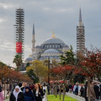Visitors walking near the Blue Mosque in Istanbul during autumn, with colorful trees in the foreground and the historic domes and minarets rising behind, Istanbul, Türkiye, Oct. 25 2025. (Shutterstock Photo) 