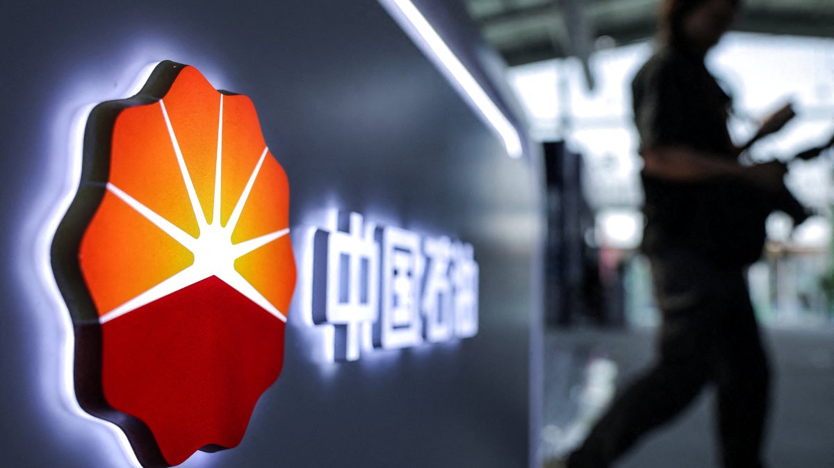 A man walks next to a logo of the China National Petroleum Corporation (CNPC), Beijing, China, Sept. 11, 2025. (Reuters Photo)