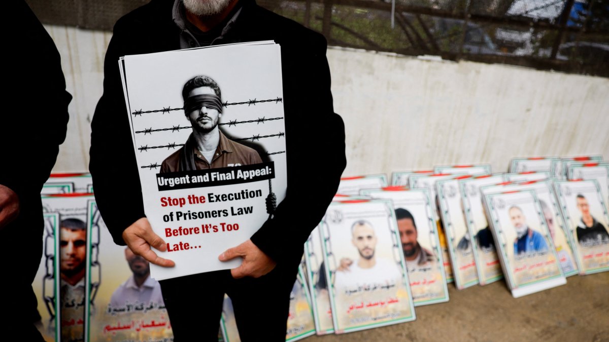 A man holds a sign as Palestinians take part in a protest against the execution of the Israeli death penalty law for Palestinians convicted of lethal attacks, Ramallah, the Israeli-occupied West Bank, Palestine, March 31, 2026. (Reuters Photo)