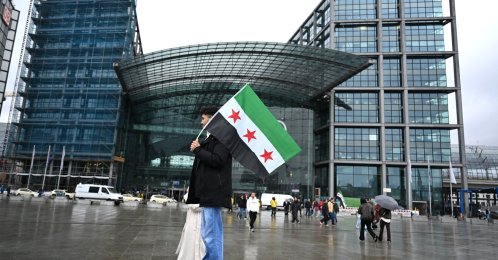 A participant holds up a Syrian flag at a pro-Syrian rally on Washingtonplatz, Berlin, March 30, 2026. (AFP Photo)