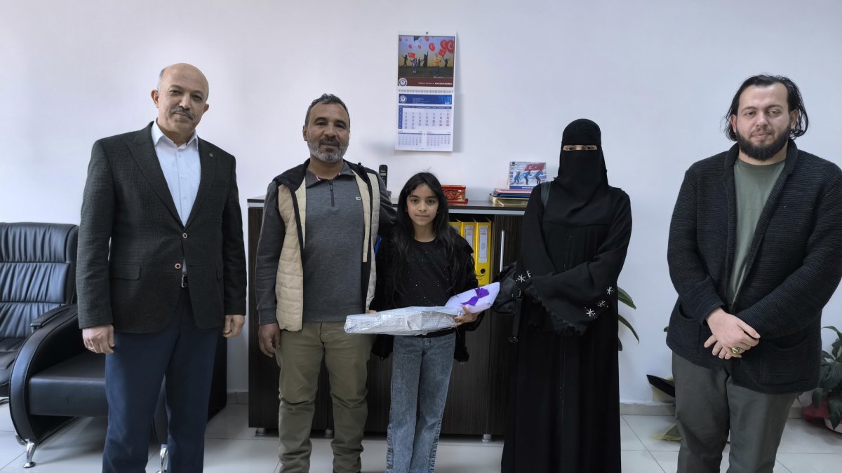 Rahaf and her parents after being congratulated and gifted by officials in recognition of her honesty, Hatay, Türkiye, April 3, 2026. (IHA Photo) 