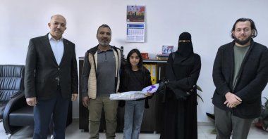 Rahaf and her parents after being congratulated and gifted by officials in recognition of her honesty, Hatay, Türkiye, April 3, 2026. (IHA Photo) 