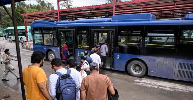 Passengers queue to board a government bus at a bus stop in Islamabad, April 3, 2026. (AFP Photo)