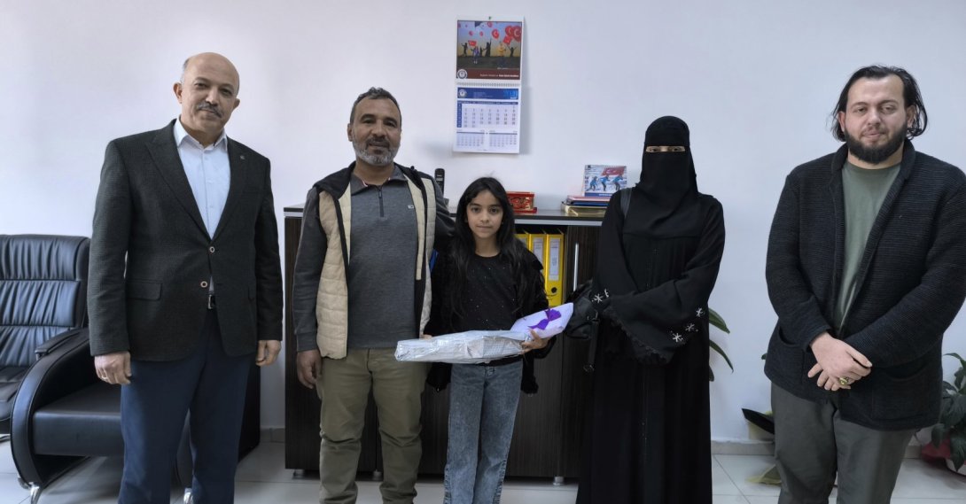 Rahaf and her parents after being congratulated and gifted by officials in recognition of her honesty, Hatay, Türkiye, April 3, 2026. (IHA Photo) 