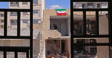 An Iranian flag is seen on a residential building that was damaged by recent strikes at Vahdat town in Karaj, southwest of Tehran, Iran, April 3, 2026. (AFP Photo)