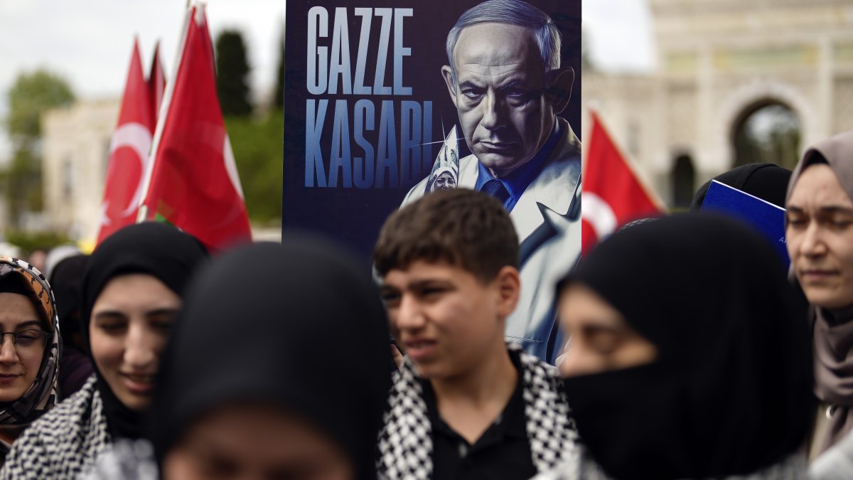 A demonstrator holds a poster of Israeli Prime Minister Benjamin Netanyahu with Turkish words that read, "Gaza Butcher" during a pro-Palestinian protest, Istanbul, Türkiye,  April 21, 2024. (AP Photo)