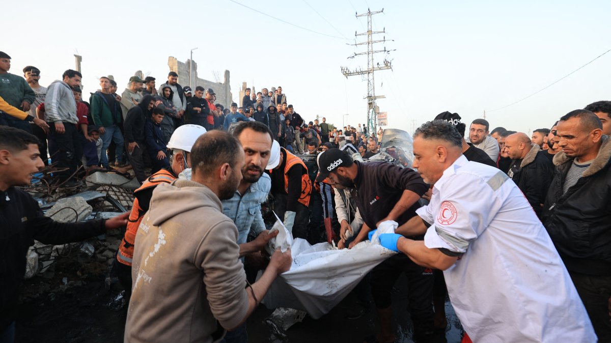 First responders and Palestinians carry parts of a body recovered from a vehicle that was targeted by an Israeli strike in Maghazi camp for Palestinian refugees in the central Gaza Strip, April 4, 2026. (AFP Photo)