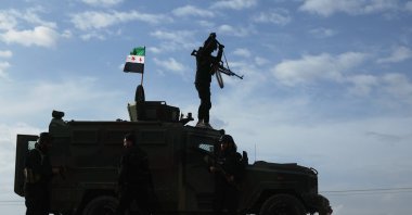 A vehicle pauses as a convoy of Syria's Interior Ministry forces passes through en route to the town of Qamishli as part of a deal with YPG, Syria, Feb. 3, 2026. (AP Photo)