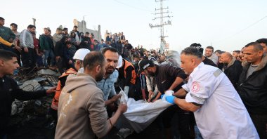 First responders and Palestinians carry parts of a body recovered from a vehicle that was targeted by an Israeli strike in Maghazi camp for Palestinian refugees in the central Gaza Strip, April 4, 2026. (AFP Photo)