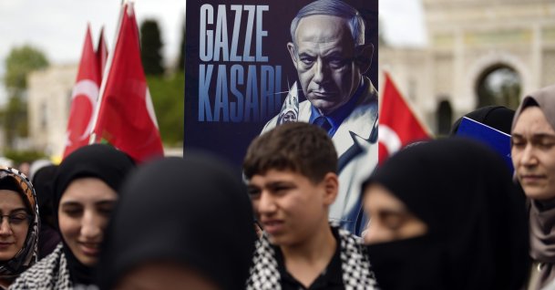 A demonstrator holds a poster of Israeli Prime Minister Benjamin Netanyahu with Turkish words that read, "Gaza Butcher" during a pro-Palestinian protest, Istanbul, Türkiye,  April 21, 2024. (AP Photo)