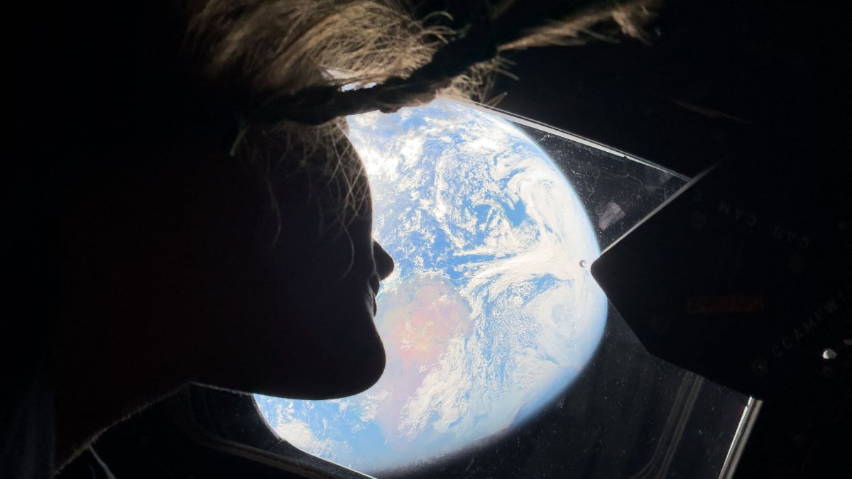 Artemis II mission specialist Christina Koch looking back at earth through the window of the Orion spacecraft, April, 2, 2026. (AFP Photo)
