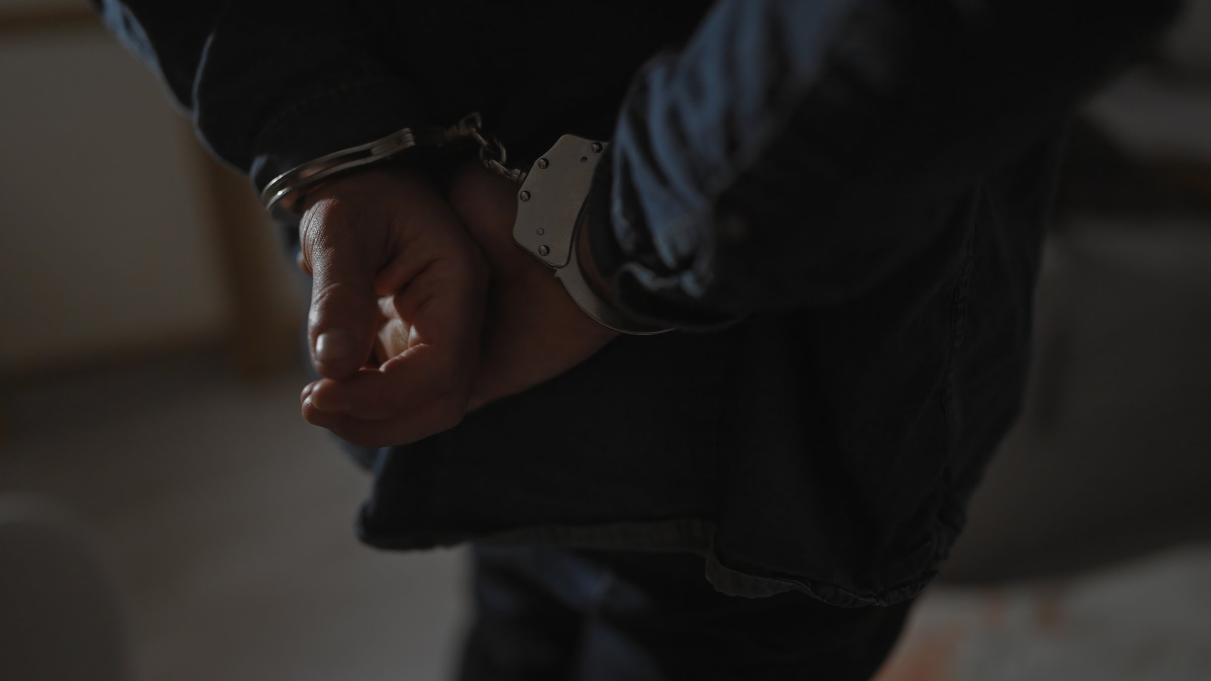 A suspect is handcuffed by police after his arrest. (Shutterstock Photo) 