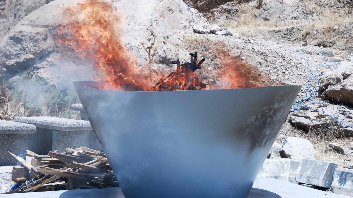 A pit filled with weapons is set on fire by members of terrorist group PKK during a ceremony in Sulaimaniyah, Iraq, July 11, 2025. (AFP Photo)