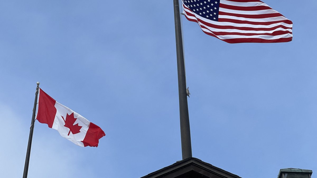 Canadian and American flags flutter against a blue sky in Maple, Ontario, Canada, Feb. 6, 2026. (AFP File Photo)