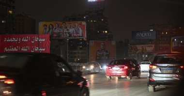 Cars drive past unlit billboards in a dark street, Cairo, Egypt, March 28, 2026. (EPA Photo)