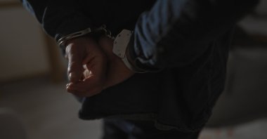 A suspect is handcuffed by police after his arrest. (Shutterstock Photo) 