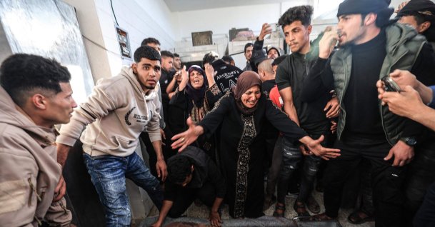Family members mourn over the body of a Palestinian victim at the Al-Aqsa Martyrs Hospital in Deir al-Balah following an Israeli strike on the Al-Maghazi refugee camp in the central Gaza Strip, April 6, 2026. (AFP Photo)