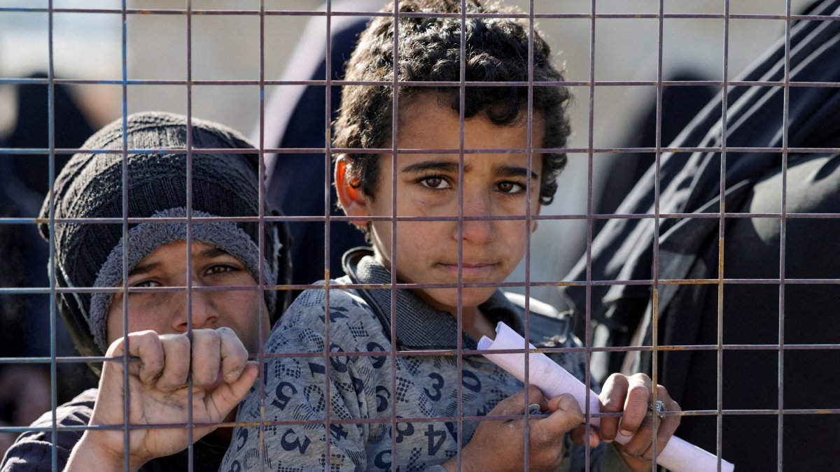 Children, part of a group of detainees, look through a fence at the al-Hol camp after the Syrian government took control of it, Hassakeh, Syria, Jan. 21, 2026. (Reuters Photo)