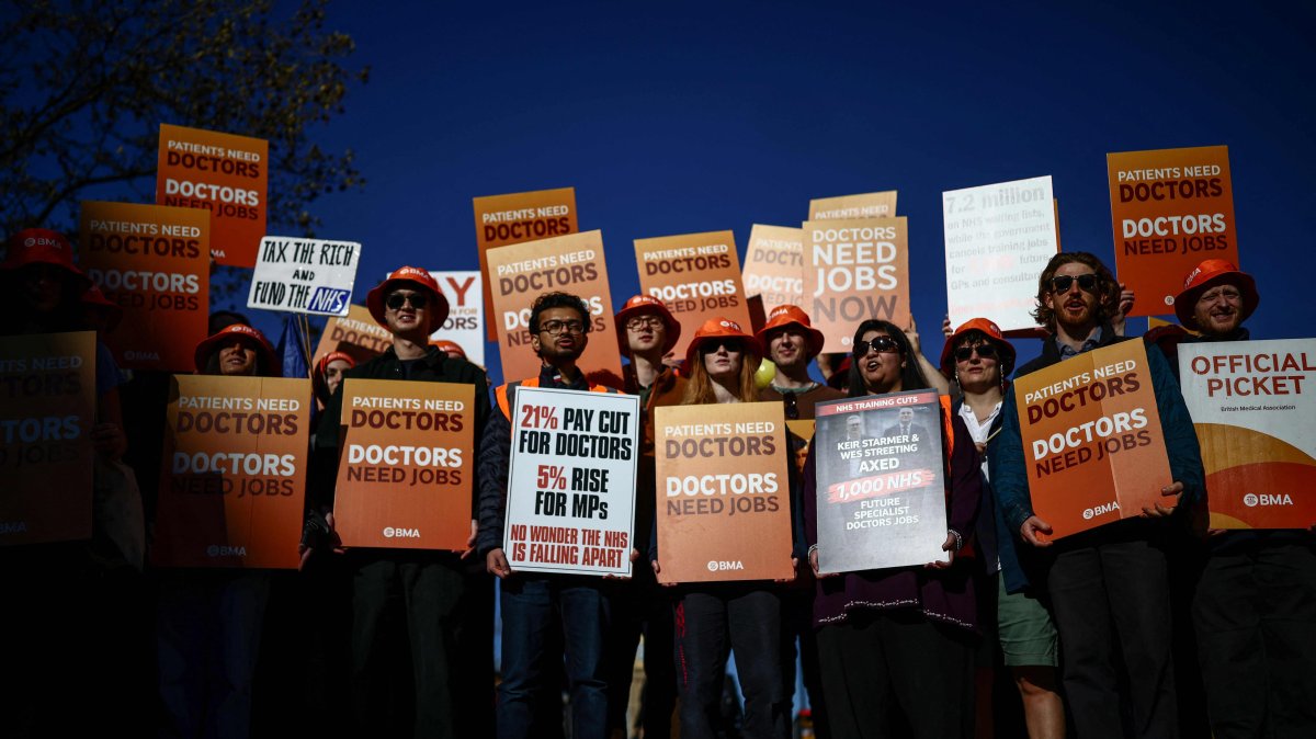 Staff members hold placards as they stand on a picket line during the first day of a six-day resident doctors' strike outside St Thomas' Hospital, central London, Britain, April 7, 2026. (Reuters Photo)