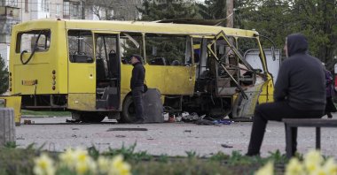 A resident looks at a municipal bus which was hit by a Russian drone strike in the town of Nikopol, in Dnipropetrovsk region, Ukraine, April 7, 2026. (Reuters Photo)