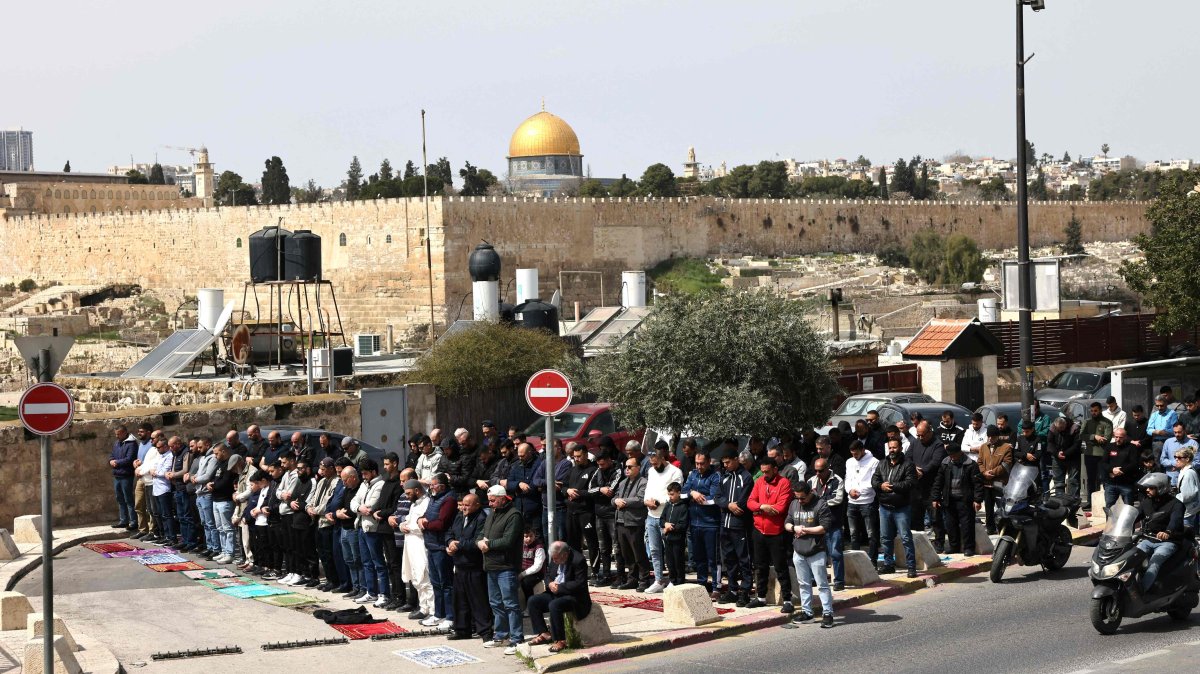 Palestinian Muslims pray during the last Friday noon prayer of the Muslim holy fasting month of Ramadan, on a street blocked by Israeli security forces in the occupied East Jerusalem neighborhood of Ras al-Amud, March 13, 2026. (AFP File Photo)