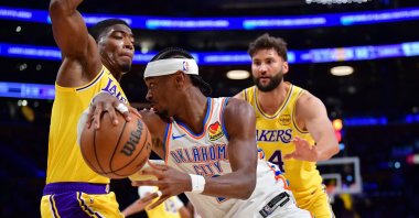 Oklahoma City Thunder's Shai Gilgeous-Alexander (C) moves the ball against Los Angeles Lakers forward Rui Hachimura (L) during the second half at Crypto.com Arena, Los Angeles, U.S., April 7, 2026. (Reuters Photo)