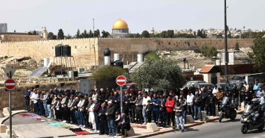 Palestinian Muslims pray during the last Friday noon prayer of the Muslim holy fasting month of Ramadan, on a street blocked by Israeli security forces in the occupied East Jerusalem neighborhood of Ras al-Amud, March 13, 2026. (AFP File Photo)
