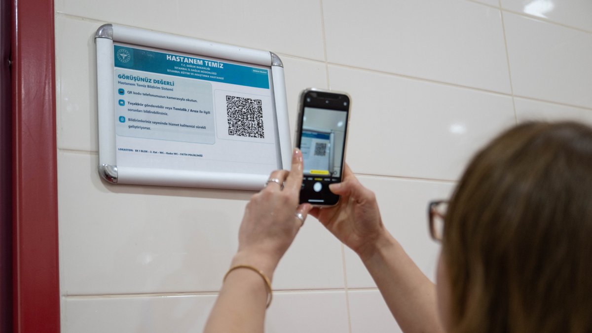 A woman scans a QR code to provide real-time feedback on hospital services, Istanbul, Türkiye, April 1, 2026. (AA Photo)