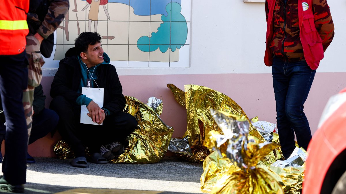 A man sits next to rescue units after an attempt to illegally cross the English Channel turned tragic, in Equihen-Plage, northern France, April 9, 2026. (AFP Photo)