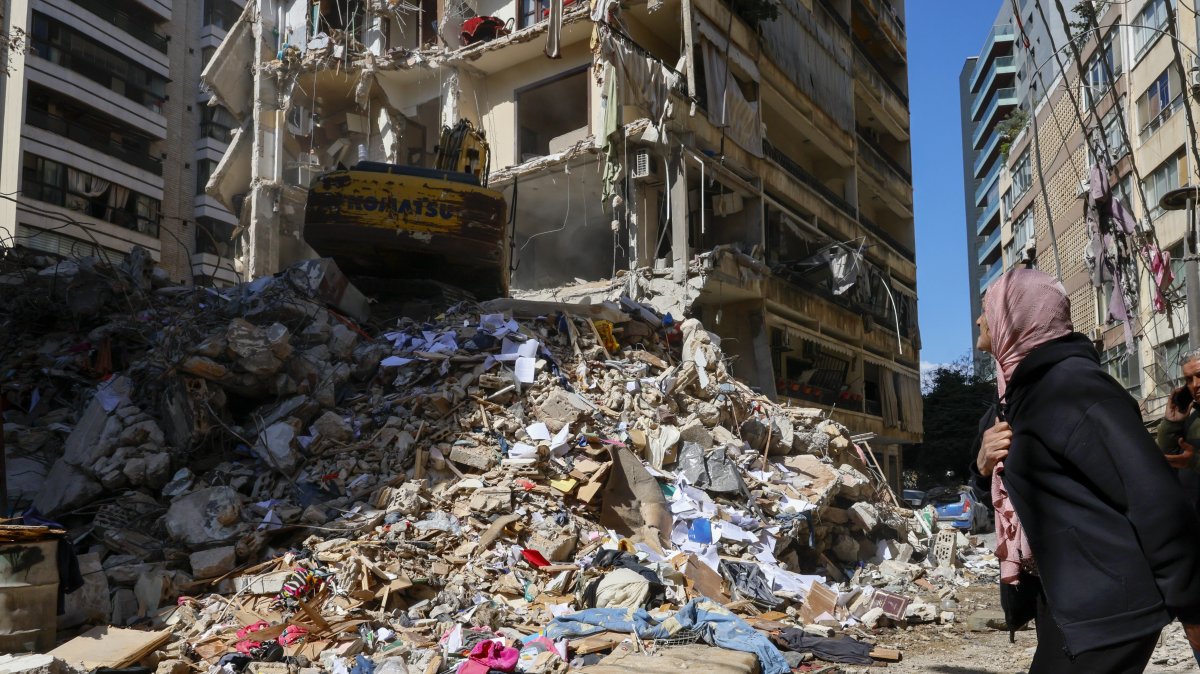 A woman watches as a bulldozer clears the rubble of a destroyed building the day after an Israeli airstrike in the Ain Mreisseh neighborhood of Beirut, Lebanon, April 9, 2026. (EPA Photo)