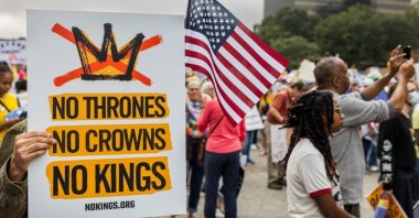 A man displays a sign reading "No thrones, no crowns, no kings" at the No Kings 2 rally, Atlanta, U.S., Oct.18, 2025. (Shutterstock Photo)