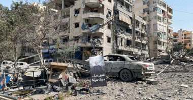 A banner with an image of Hezbollah leader Naim Qassem next to damaged buildings in the aftermath of Israeli strikes, in Beirut's southern suburbs, Lebanon, March 12, 2026. (Reuters Photo)