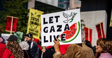 A protester holds a sign reading "Let Gaza live" and featuring a watermelon illustration, Toronto, Canada, Sept. 20, 2025. (Shutterstock Photo)
